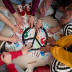 AdobeStock_497034183_1500Px_square Foto Personen legen ihre Hände auf ein Peace-Motiv