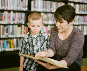 Frau und Junge lesen ein Buch gemeinsam