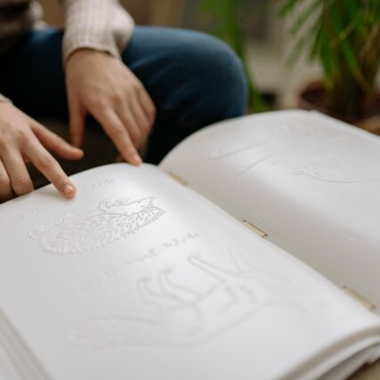 Buch mit Schrift und Tierbildern in Braille.